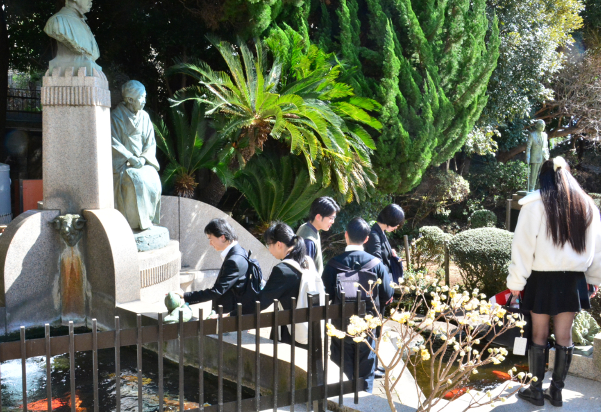 大きく育った鯉を眺めて、驚きの様子。和夫先生と春子先生の像が、優しく見守ってくださっていた